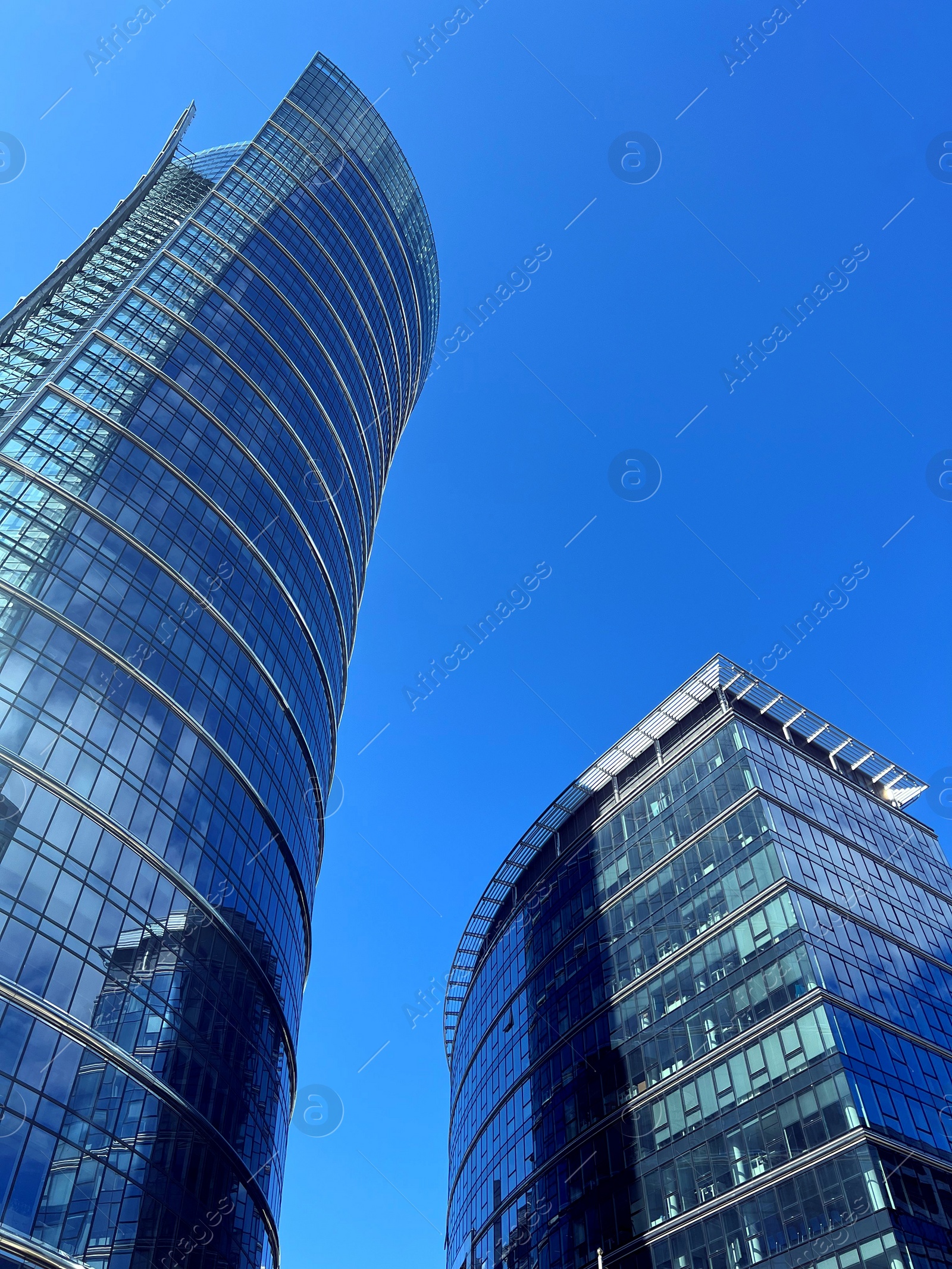 Photo of Low angle view of modern business complex under blue sky
