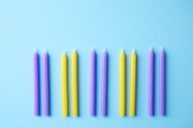Photo of Colorful birthday candles on light blue background, flat lay