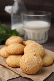 Photo of Tasty sweet sugar cookies and milk on brown table, closeup