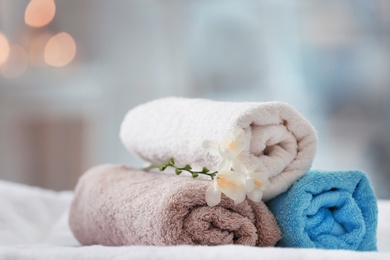 Photo of Towels and flowers on massage table in spa salon