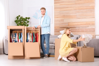 Photo of Young couple near wardrobe boxes at home