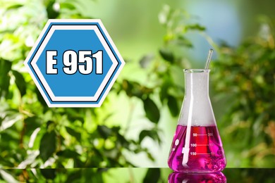 Image of Information about artificial sweetener in product. Blue sign with aspartame code (E951) and flask with liquid on table outdoors