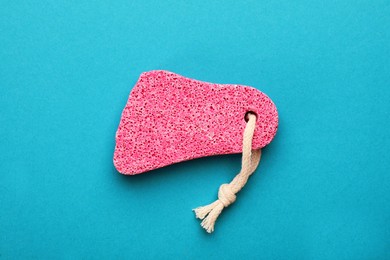 Photo of Pink pumice stone on light blue background, top view