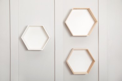 Photo of Empty honeycomb shaped shelves on white wall
