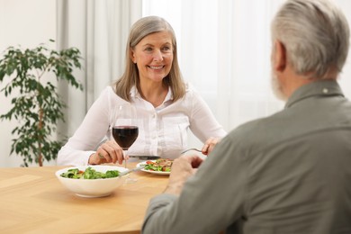 Photo of Happy senior couple having romantic dinner at home