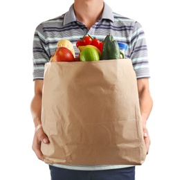 Photo of Man holding paper bag with different groceries on white background, closeup view