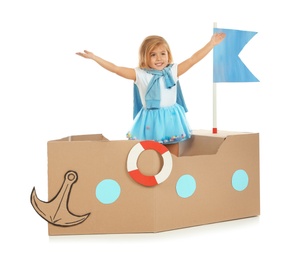 Photo of Cute little girl playing with cardboard ship on white background