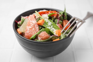 Photo of Delicious salad with pomelo, tomatoes and cheese on white tiled table, closeup