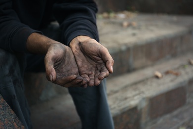 Photo of Poor homeless man begging for help outdoors, closeup