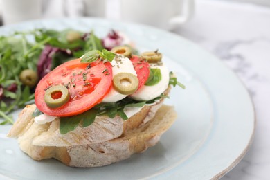 Photo of Tasty bruschetta with tomatoes, olives and mozzarella served on plate, closeup