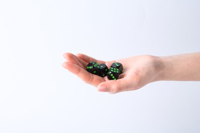 Photo of Woman holding game dices in hand on white background, closeup