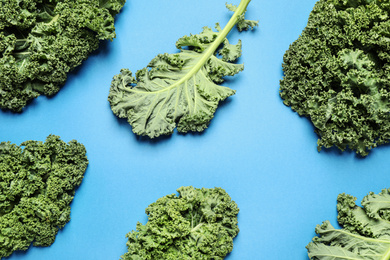 Photo of Fresh kale leaves on blue background, flat lay