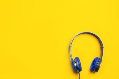 Photo of Stylish headphones on color background, top view. Space for text
