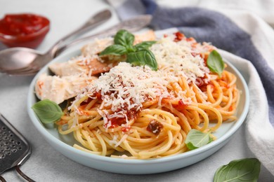Photo of Delicious pasta with tomato sauce, chicken and parmesan cheese on white table, closeup