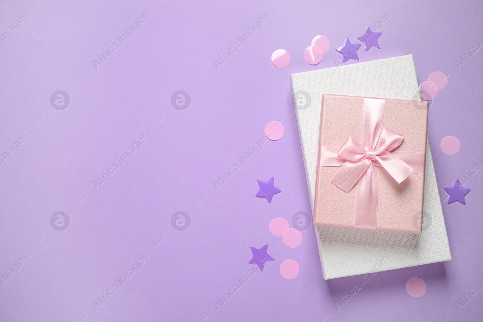 Photo of Beautiful gift boxes and confetti on violet background, flat lay. Space for text