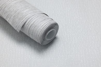 Photo of Wallpaper roll on light grey sample, space for text