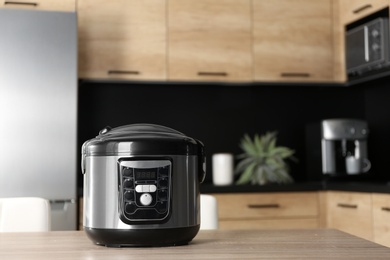 Photo of Modern multi cooker on table in kitchen, space for text