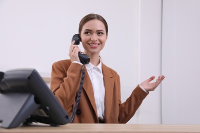 Photo of Female receptionist talking on phone at workplace