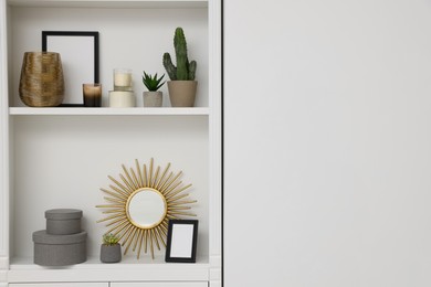 Photo of Beautiful houseplants and different decorative elements on shelving unit, space for text
