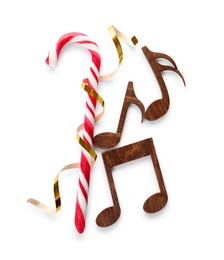Photo of Composition with wooden music notes and candy cane on white background, top view