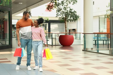 Photo of Family shopping. Happy couple with colorful bags in mall