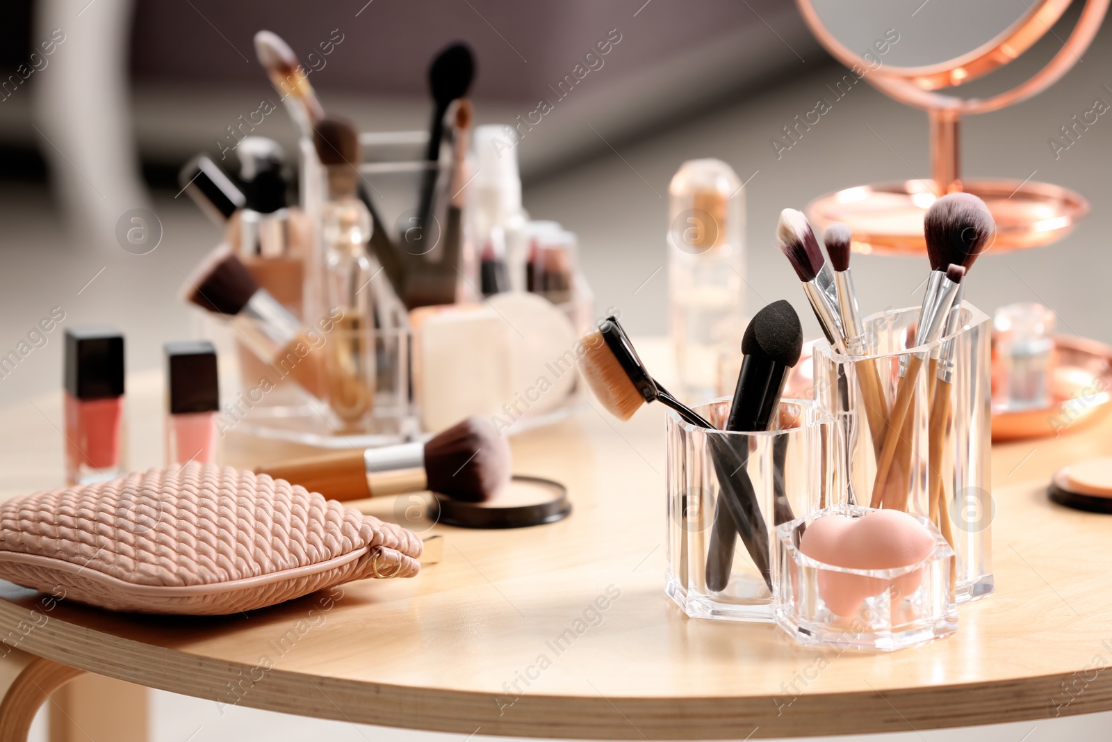 Photo of Makeup accessories and cosmetic products on table against blurred background