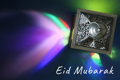 Image of Eid Mubarak greeting card. Arabic lantern on color background, top view