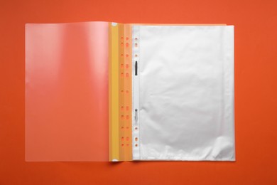 Photo of File folder with punched pockets on orange background, top view