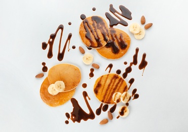 Photo of Delicious pancakes with chocolate syrup and banana on white background