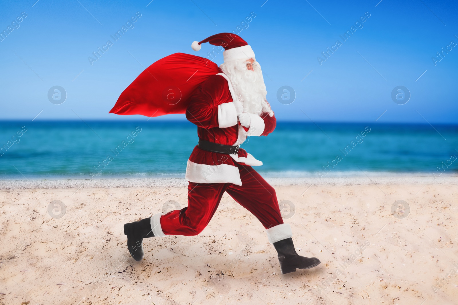 Image of Santa Claus with red sack on beach near sea . Christmas vacation 