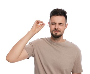 Photo of Young man cleaning ear with cotton swab on white background