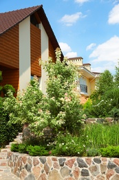 Landscape with modern house and beautiful garden on sunny day