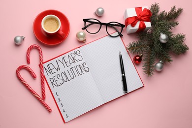 Photo of Making New Year's resolutions. Flat lay composition with notebook and festive decor on pink background