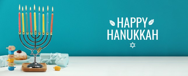 Image of Happy Hanukkah. Menorah, donut, dreidels and gifts on white table, banner design