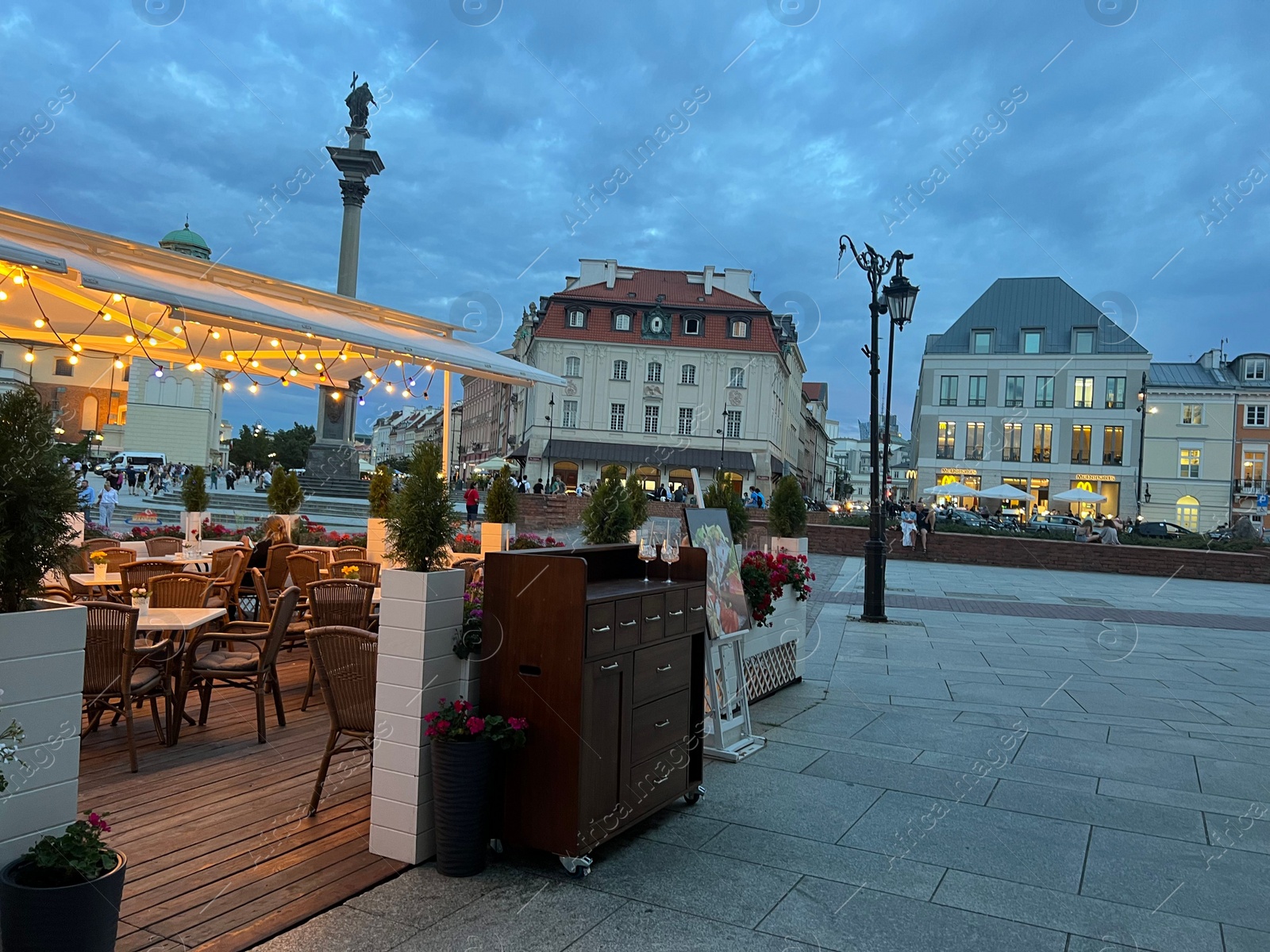 Photo of WARSAW, POLAND - JULY 15, 2022: Crowded Old Town Market Place and outdoor cafe terraces in evening