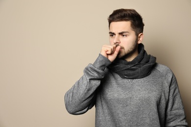 Photo of Handsome young man coughing against color background. Space for text