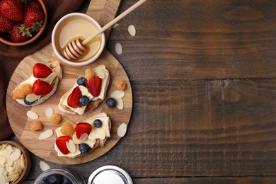 Photo of Tasty brie cheese sandwiches on wooden table, flat lay. Space for text