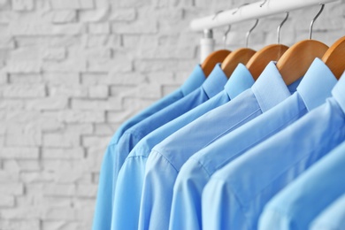 Photo of Rack with clean clothes on hangers after dry-cleaning indoors