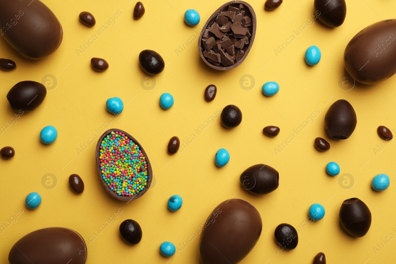 Photo of Flat lay composition with chocolate Easter eggs on color background