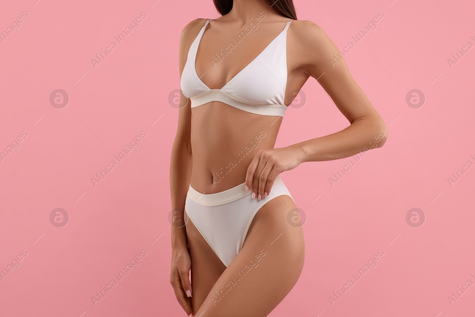 Photo of Young woman in stylish white bikini on pink background, closeup