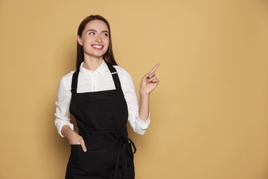 Portrait of happy hairdresser on beige background. Space for text