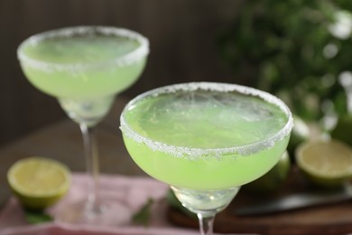 Photo of Delicious Margarita cocktail in glasses on table, closeup