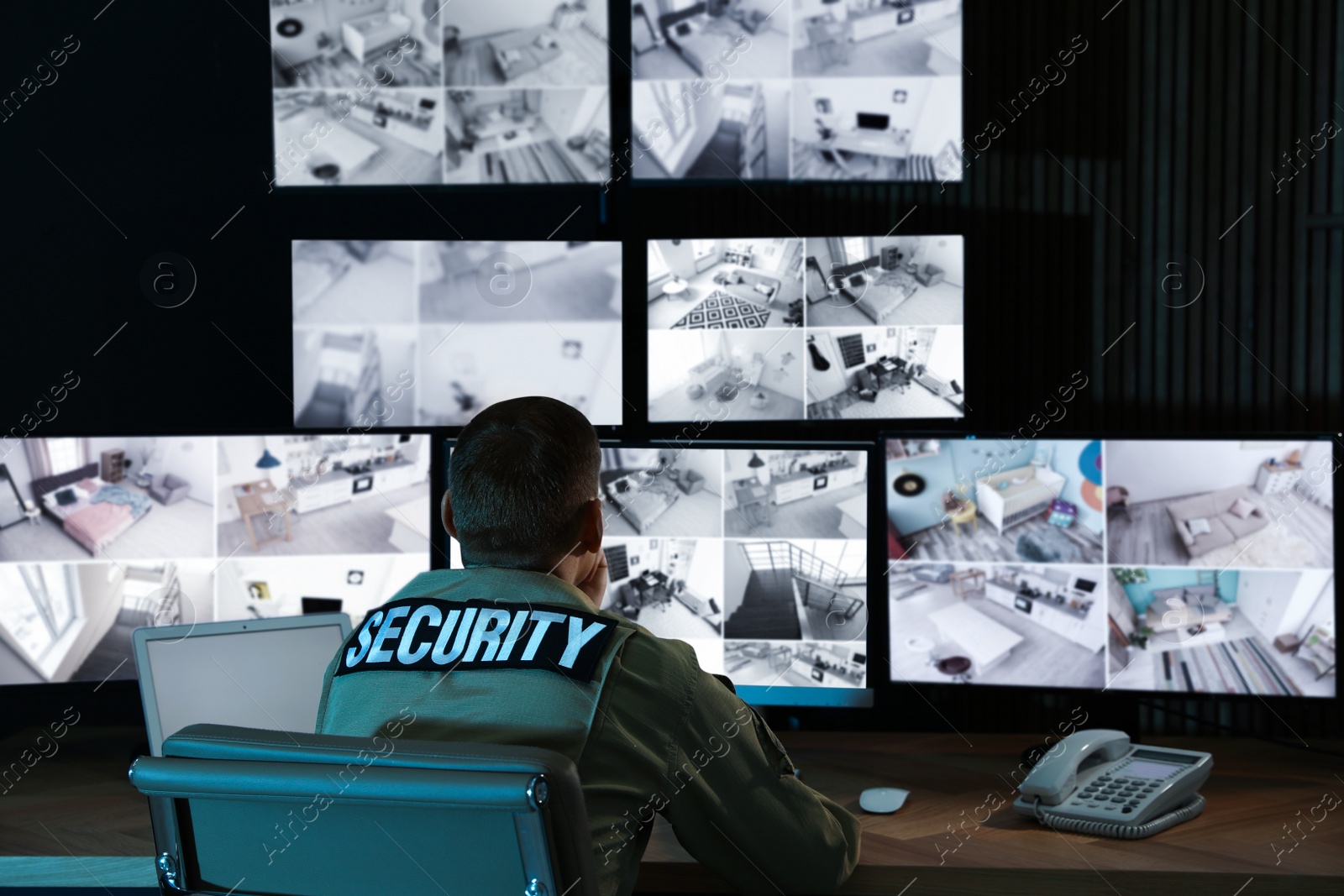 Photo of Security guard monitoring modern CCTV cameras in office