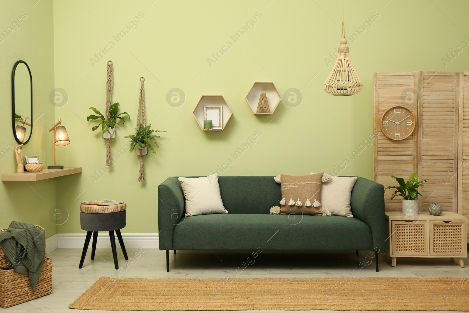 Photo of Living room with comfortable green sofa. Interior design