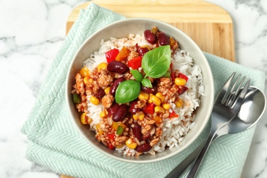 Photo of Tasty chili con carne served with rice on marble table, flat lay