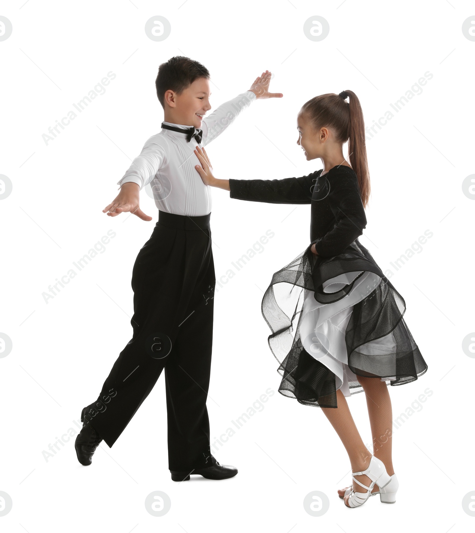 Photo of Beautifully dressed couple of kids dancing on white background