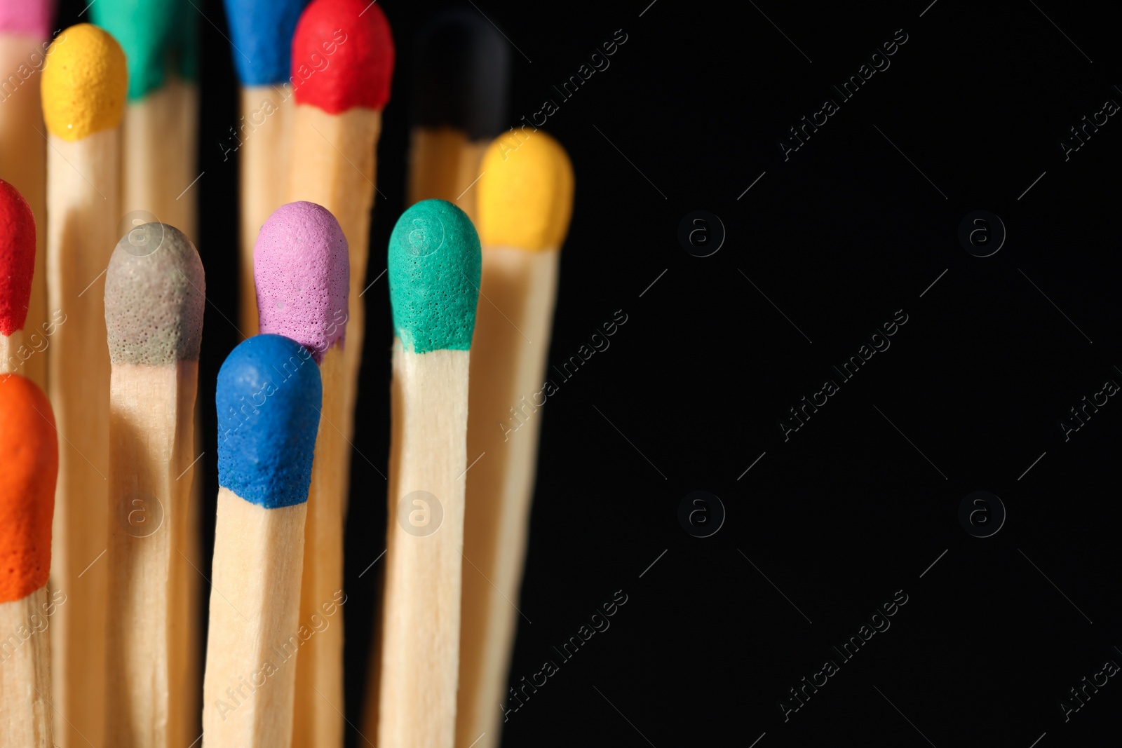 Photo of Matches with colorful heads on black background, closeup. Space for text