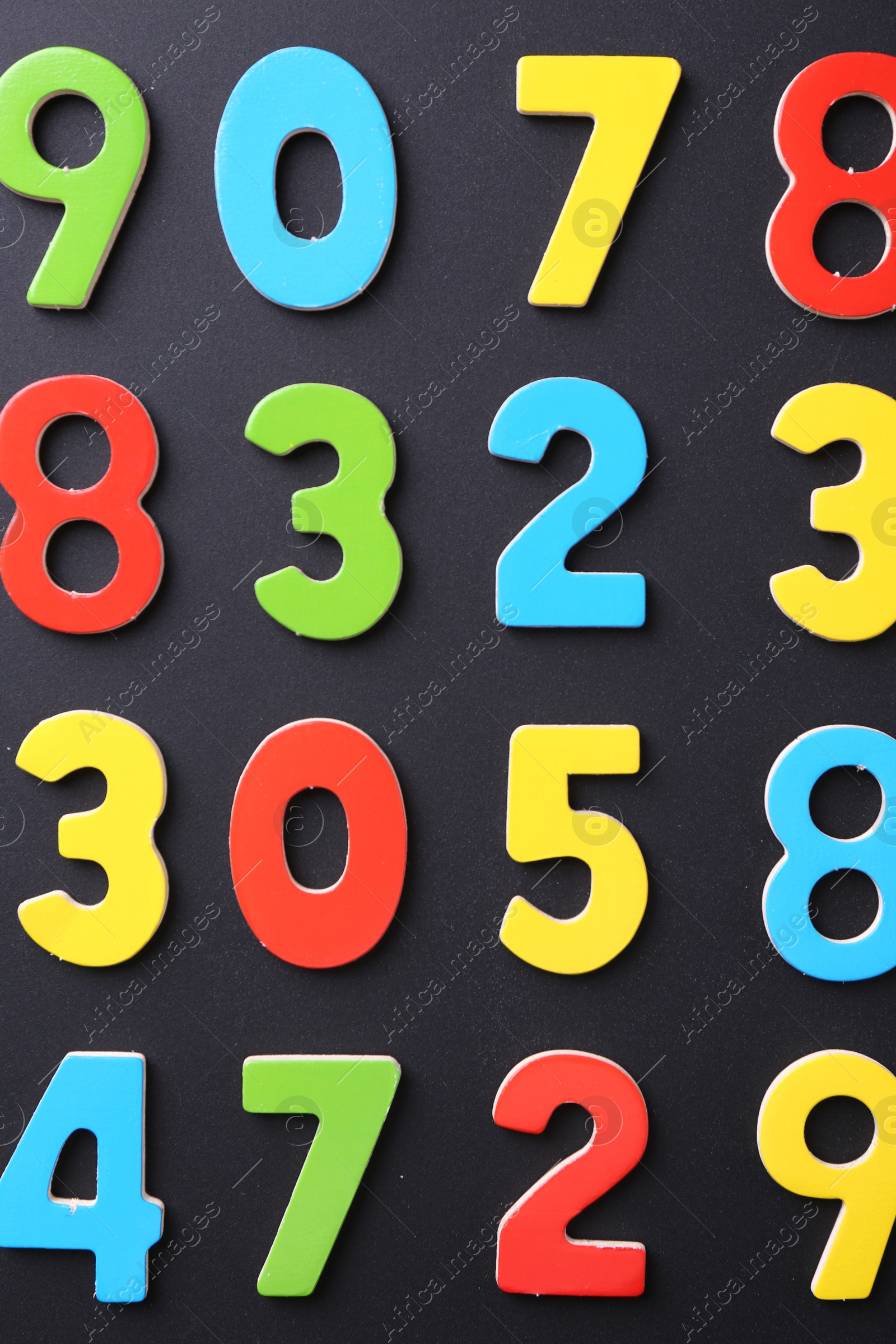 Photo of Colorful numbers on black background, flat lay