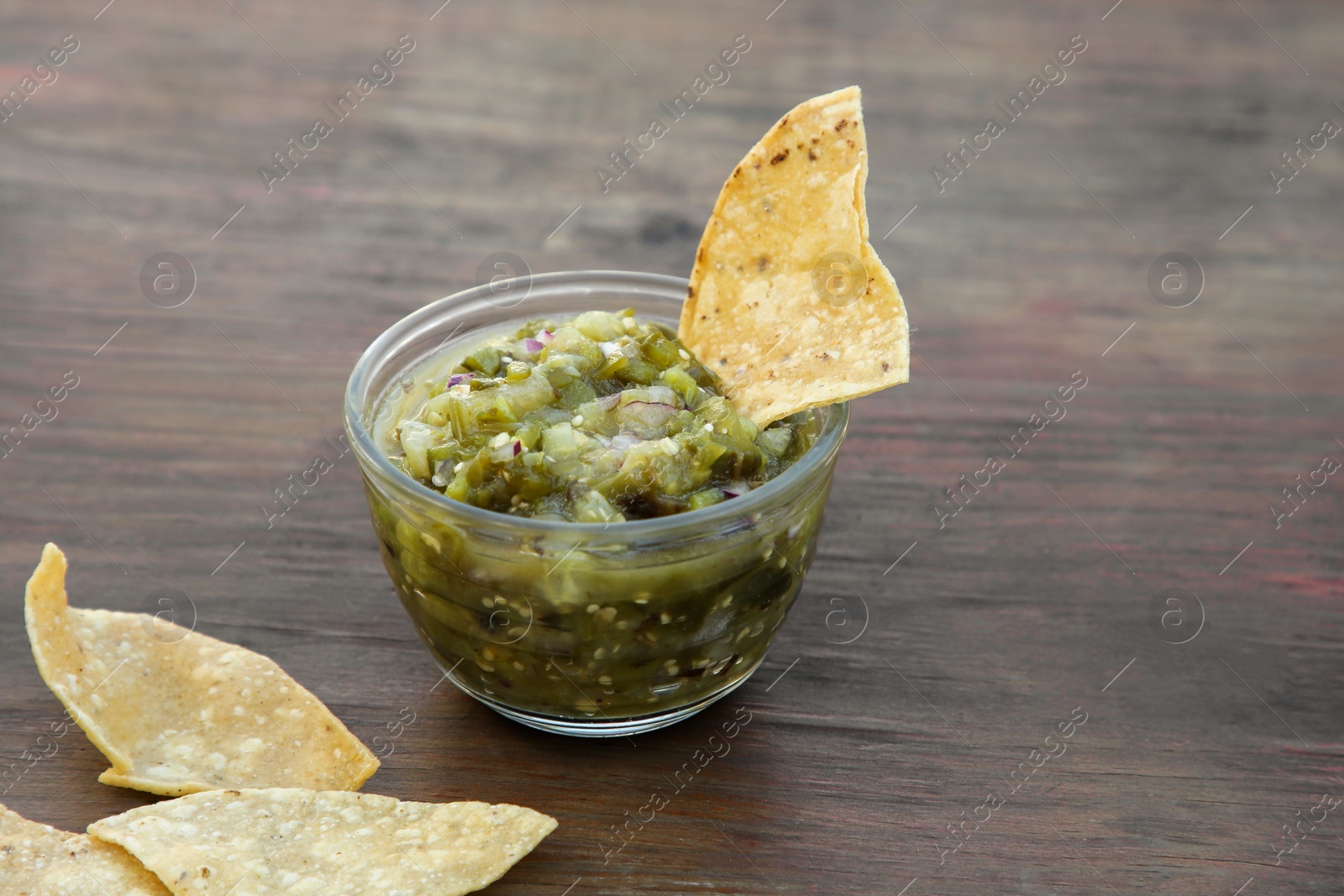 Photo of Tasty salsa sauce and tortilla chips on wooden table, closeup