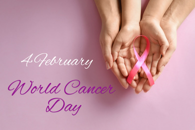 Woman and child holding pink ribbon on color background, top view. World Cancer Day